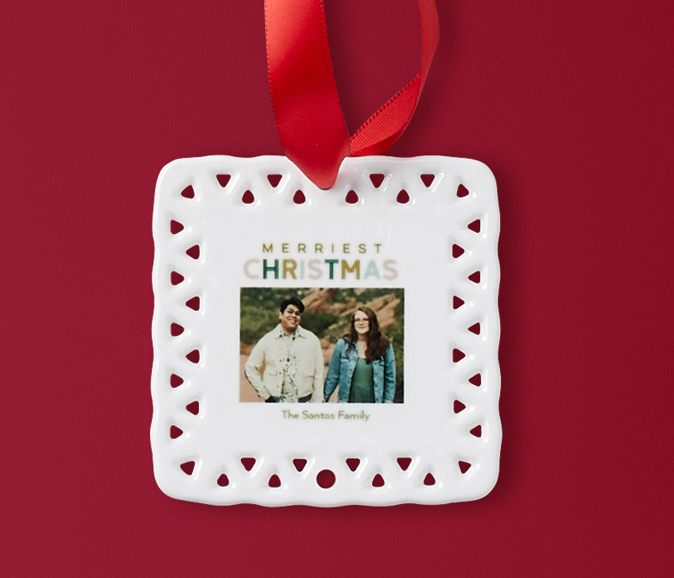 A white personalized ceramic ornament that says Merriest Christmas with a picture of a couple