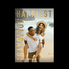 A personalized holiday card that says Happiest Holidays with a picture of a couple on the beach