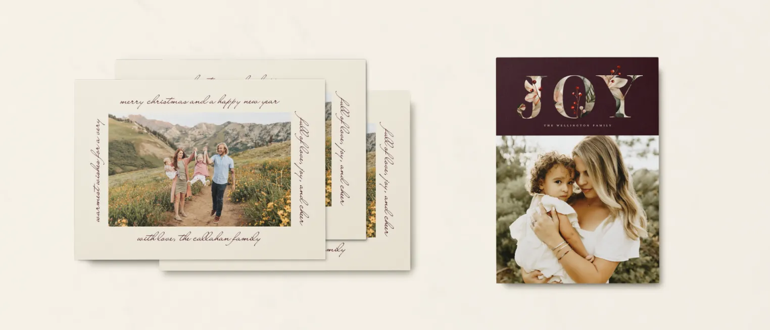 Holiday cards featuring a family photo in a mountain meadow and a design with the word JOY in floral letters.